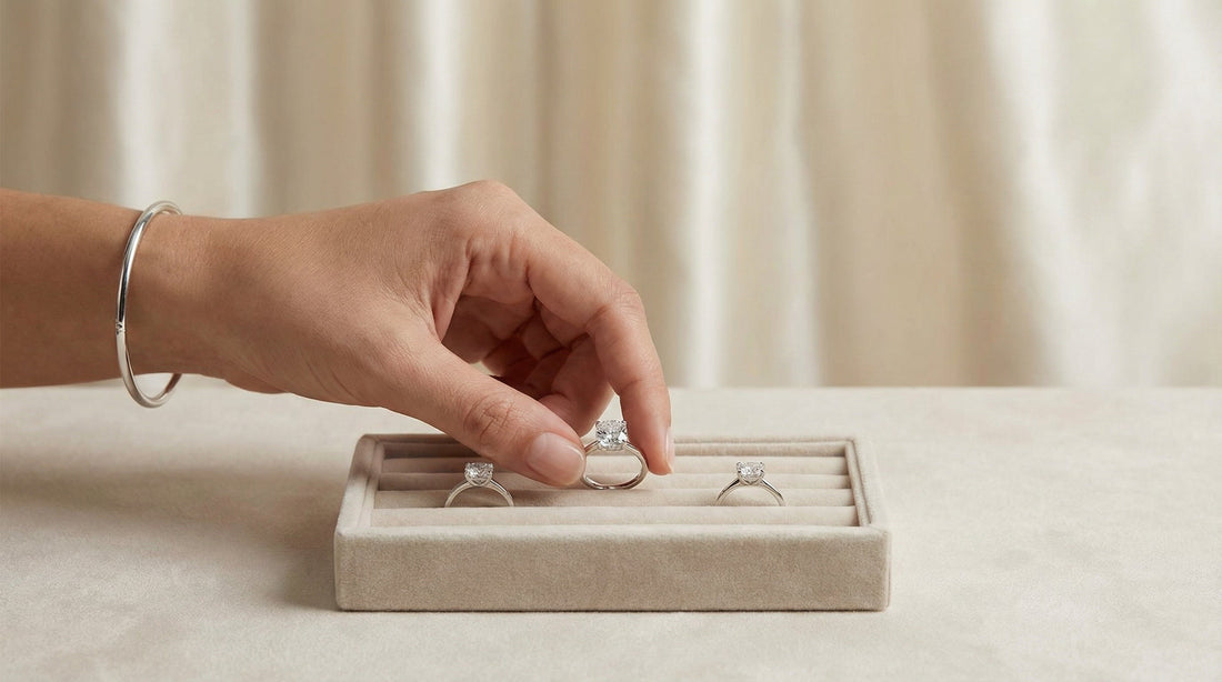 Hand selecting a fine jewelry ring from a curated tray, illustrating the careful selection process behind a Glacier & Aurealis jewelry collection.